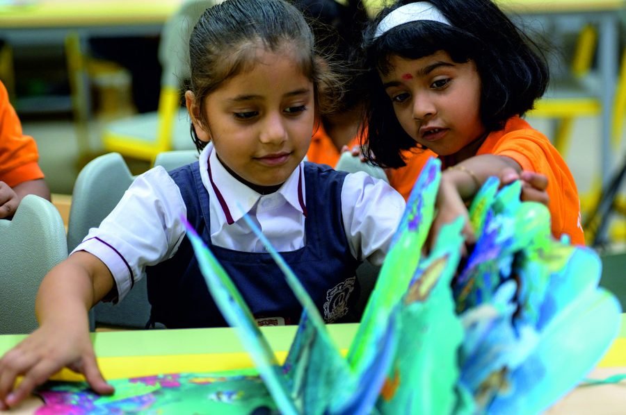 Two students working together on a paper craft project
