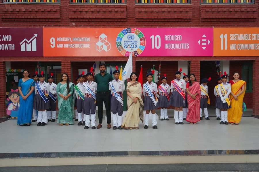 Student prefects and staff with the school's SDG display
