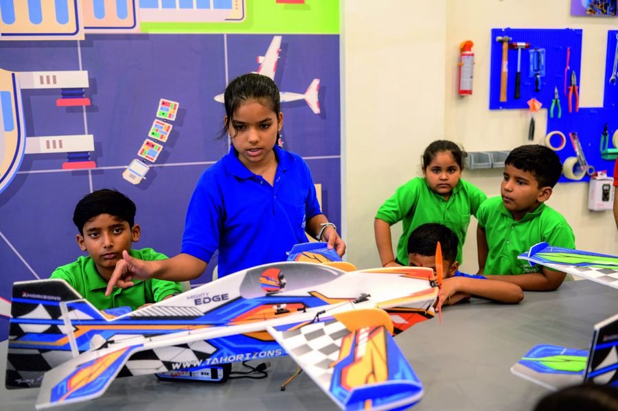 A group of students working on a model aircraft in the robotics lab