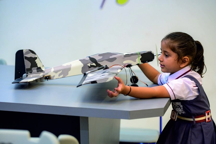 A student testing a model aircraft in the robotics lab