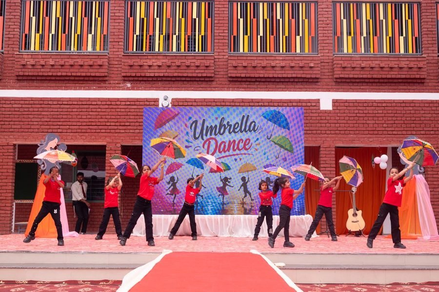 Students performing an umbrella dance on stage